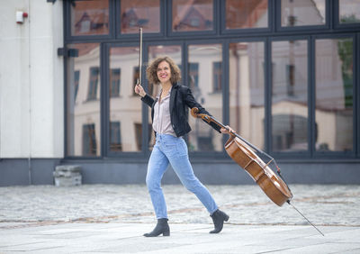 Full length of woman with violin on street