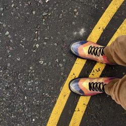 Low section of man standing on road