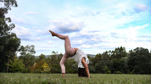 Full length of man with arms raised against sky