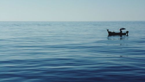 Silhouette people in calm sea