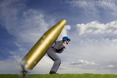 Man holding umbrella on field