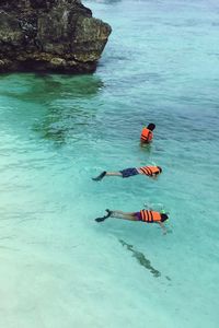 High angle view of friends snorkeling in sea