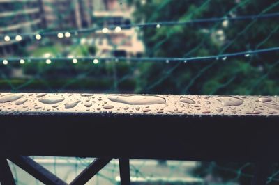 Close-up of raindrops on railing