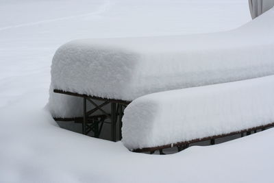 Snow covered table and benches on field