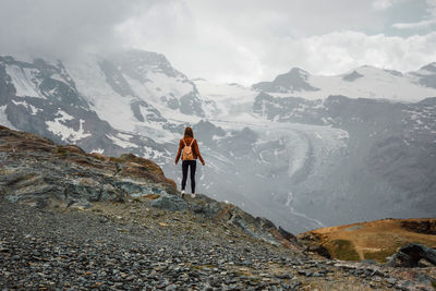 Woman with backpack on mountain background. top of gornergrat, zermatt, swiss. hiking in alps