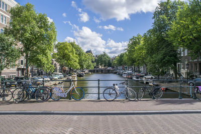 Bicycle by river against sky in city