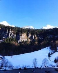 Scenic view of snowcapped mountains against clear blue sky