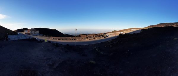 Panoramic view of sea and mountains against clear blue sky