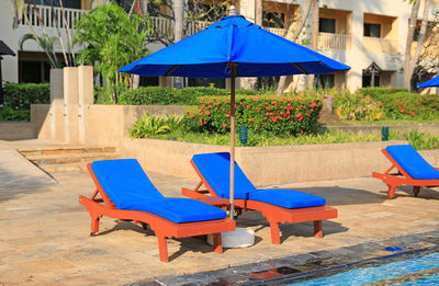 Empty chairs and tables against building