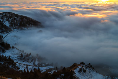 Scenic view of snow covered mountains against sky during sunset