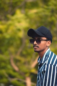 Portrait of young man wearing sunglasses standing outdoors