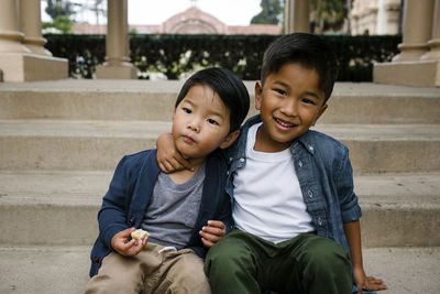 Portrait of cute boy sitting with brother on steps at balboa park