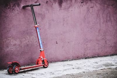 Bicycle on footpath against wall