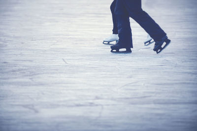 Low section of couple skating on ice