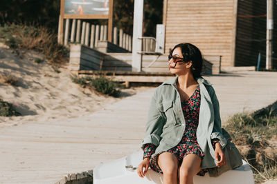 Portrait of young woman wearing sunglasses while standing on street