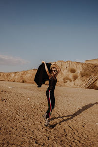 Full length of man standing in desert against sky