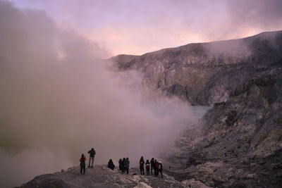 People on mountain range against sky