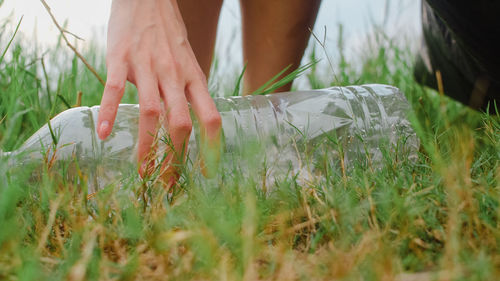 Midsection of woman holding hands on field