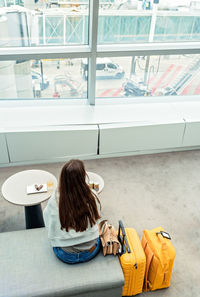 Rear view of woman sitting on table