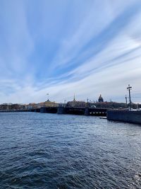 Sea by city against sky