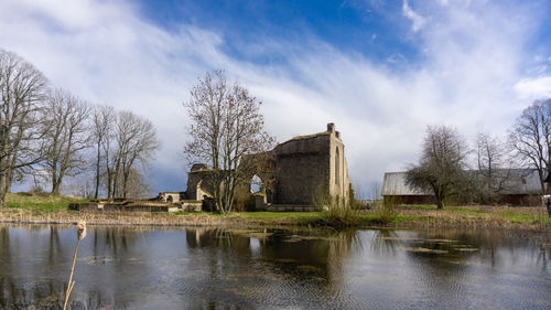 Buildings by lake against sky