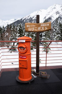 Information sign on snowcapped mountain