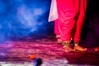 Low section of women standing on floor during night