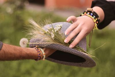 Cropped image of hands holding hat