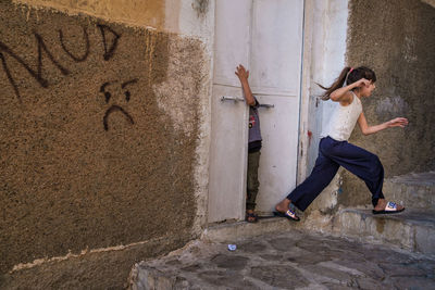 Full length of young woman on wall