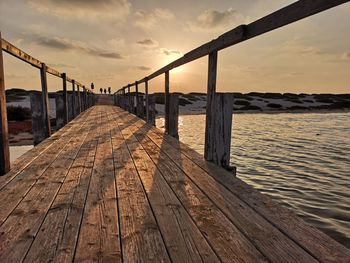 Pier over sea against sky during sunset