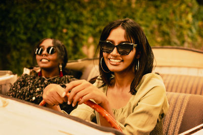 Portrait of smiling friends driving a convertible car 
