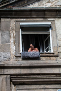 Young couple relaxing on window of building