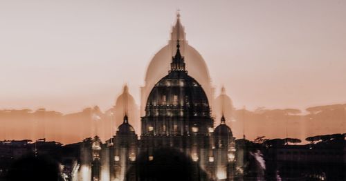 Buildings in city against sky during sunset