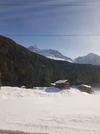 Scenic view of snow covered land and mountains against sky