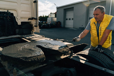 Side view of man sitting on street