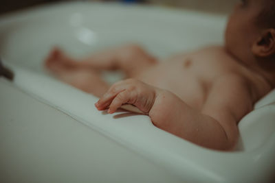 Closeup of baby hand lying on bathtub