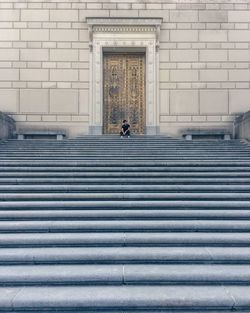 Rear view of woman walking on staircase of building