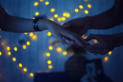 Close-up of hands on illuminated lighting equipment