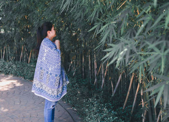 Woman with scarf standing by plants