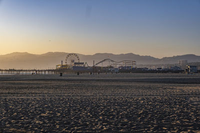 Scenic view of beach against clear sky during sunset