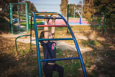 Girl playing on jungle gym in park