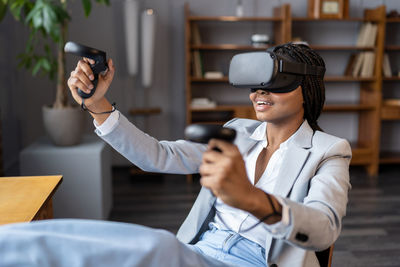 Young woman using mobile phone while sitting on table