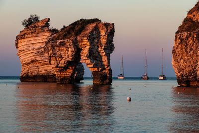 Scenic view of rock formation in baia delle zagare at sunrise - apulia, italy