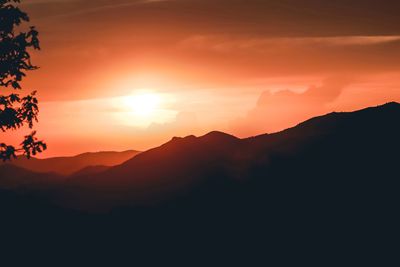 Scenic view of silhouette mountains against romantic sky at sunset