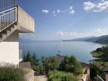 Scenic view of sea by buildings against sky