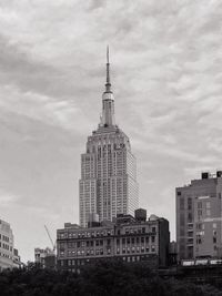 Buildings in city against cloudy sky