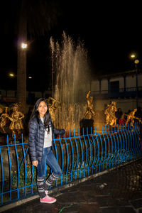 Portrait of young woman standing at night