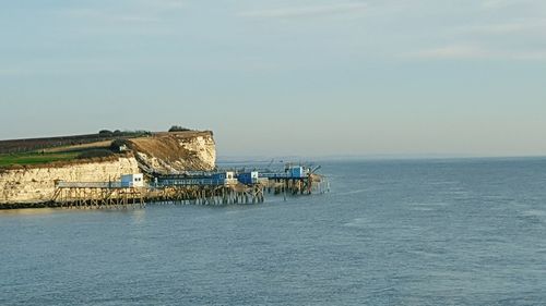 Scenic view of piers in sea against sky