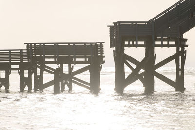 Pier in calm sea against clear sky