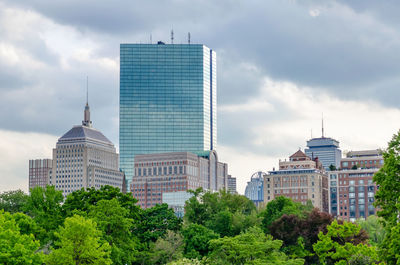 Buildings in city against cloudy sky